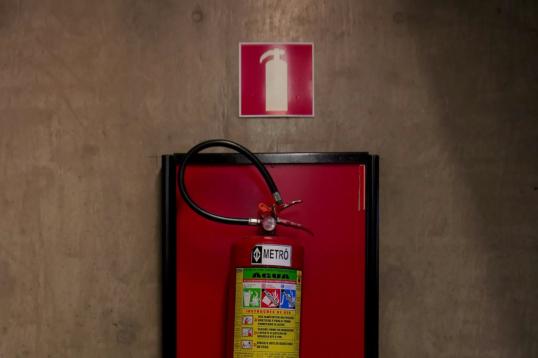 Extintor de incêndio em suporte vermelho, em conformidade