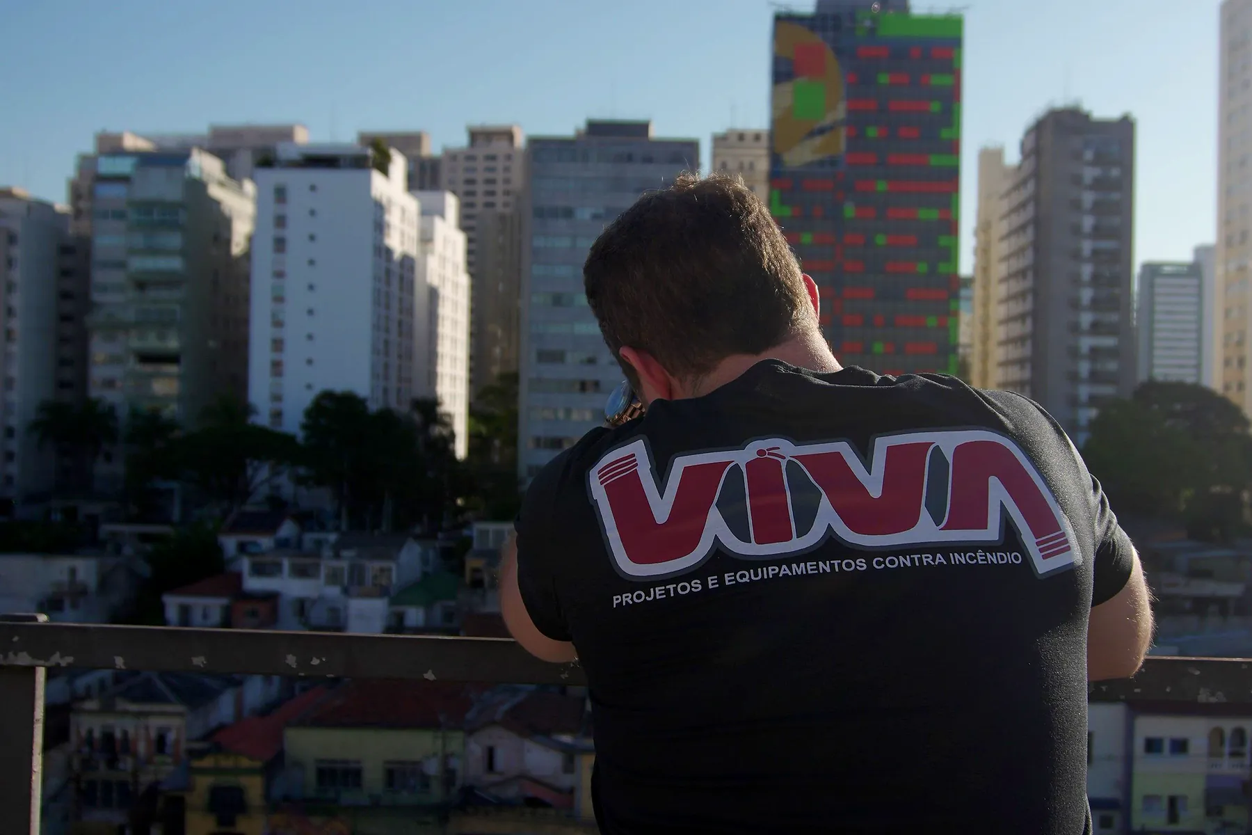 Engenheiro da VIVA de costas, na cobertura, olhando a cidade de São Paulo